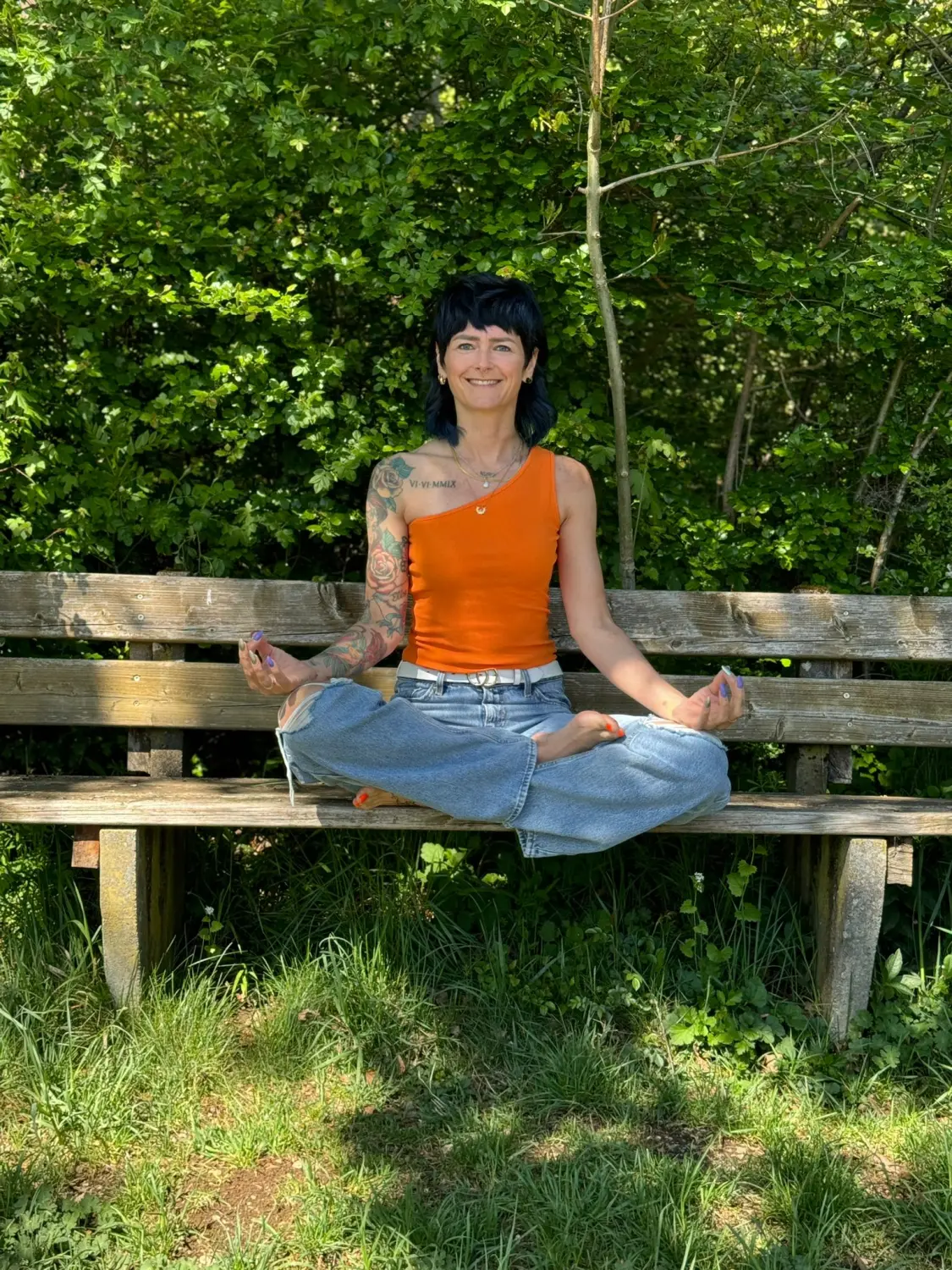 Menschen sitzen im Freien auf Yogamatten